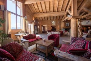 un grand salon avec des canapés et une table dans l'établissement CGH Résidences & Spas Le Village De Lessy, au Grand-Bornand