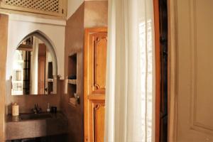 a bathroom with a sink and a door with a mirror at Riad Miski in Marrakesh