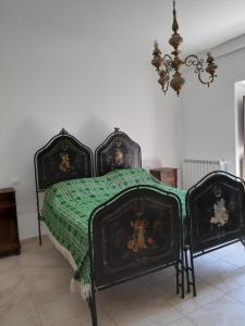 a bedroom with two beds and a chandelier at Casa Iacobucci in Fagnano Alto