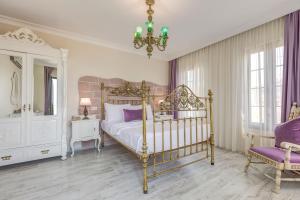 1 dormitorio con 1 cama, 1 silla y 1 lámpara de araña en Cunda Esen Hotel, en Ayvalık