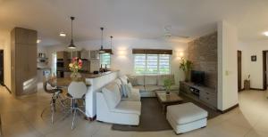 Una sala de estar y una cocina con un sofá y una mesa. en Superbe Villa privée, en Flic en Flac