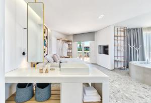 een witte badkamer met een wastafel en een bad bij Arkadia Hotel in Kypseli