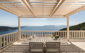 a patio with a table and chairs on a balcony at Urania Luxury Villas in Vasiliki