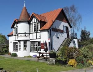 a large white house with a red roof at The Old Stables Pub with rooms in Moffat