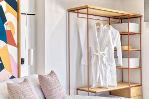 a wardrobe with white coats and towels on it at Arkadia Hotel in Kypseli