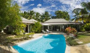 una casa con piscina delante de una casa en Superbe Villa privée, en Flic en Flac