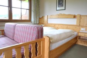 a bedroom with a wooden bed and a bench at Pension Möslehnerhof in Ramsau am Dachstein