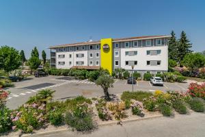 un edificio con un estacionamiento delante de él en B&B HOTEL Salon de Provence, en Salon-de-Provence