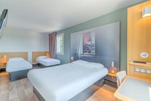 a bedroom with a large white bed in a room at B&B HOTEL Salon de Provence in Salon-de-Provence