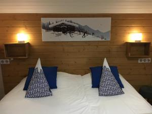 een slaapkamer met een bed met blauwe en witte kussens bij Hotel la Turra in Termignon