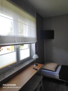 a bedroom with a bed and a desk with a window at Morze u Moni in Karwieńskie Błoto Pierwsze