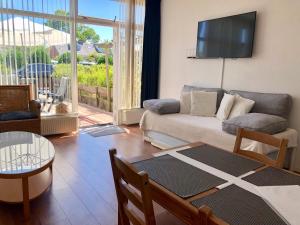 ein Wohnzimmer mit einem Sofa und einem TV an der Wand in der Unterkunft Reumann Holiday Apartments: De Schelp in Zandvoort