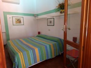 a bedroom with a striped bed in a room at Villa Saracina in Vulcano