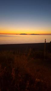a sunset over the ocean with a fence in the foreground at B&B Le Tre Stelle in Milazzo