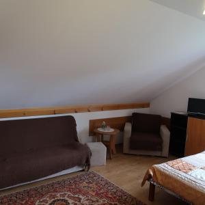 ein Wohnzimmer mit einem Sofa und einem Stuhl in der Unterkunft Agroturystyka Kresówka in Lubycza Królewska