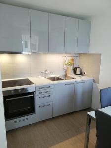 una cocina con armarios blancos y fregadero en Apartment Vista Viganj, en Viganj