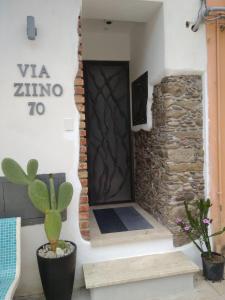 a door to a room with a stone wall and a plant at Via Ziino 70 in Oliveri