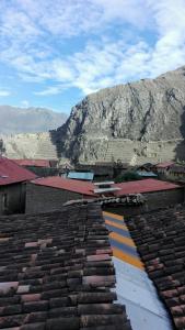 una vista de los tejados de los edificios con montañas en el fondo en B&B Chayana Wasi en Ollantaytambo