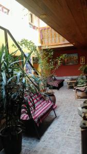 a patio with a bench and potted plants at B&B Chayana Wasi in Ollantaytambo