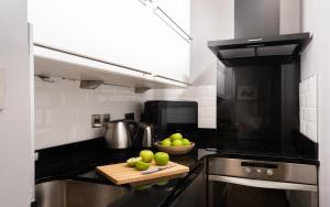 a kitchen with a bowl of apples on a cutting board at Contemporary 1 Bed in Pimlico in London