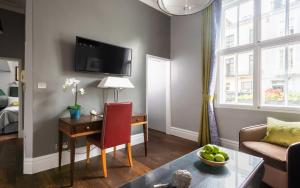 a living room with a desk and a room with a bed at Contemporary 1 Bed in Pimlico in London