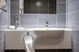 a bathroom with a sink and a bath tub at Burleigh Court Hotel and Leisure in Loughborough