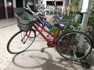 uma bicicleta vermelha com um cesto estacionado no passeio em Ban Maitree em Chiang Mai