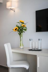 プラヤ・ハンディアにあるAparthotel Esquinzo Y Monte Del Marの白い椅子とテーブルの花瓶