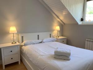 a bedroom with a large white bed with two lamps at BPIRINEOS-Blest in Benasque +10 photos