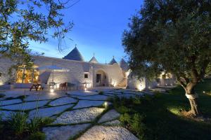 a courtyard of a house with a tree and lights at Trulli Santa Croce - Luxury Holiday - in Locorotondo