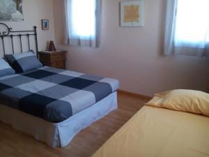 a bedroom with a bed and a night stand and window at La Era en Guara in Ibieca