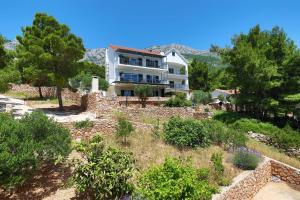 a house on top of a hill with trees at REDSTONE luxury apartments in Hvar