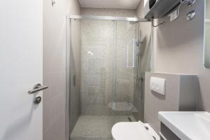 een badkamer met een douche, een toilet en een wastafel bij Villa Mimoza in Cavtat