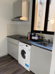 a kitchen with a washing machine and a sink at Sweet Home Paris Apartment in Paris