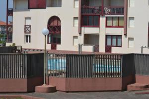 a fence in front of a building with a pool at Appartement à 50m de la plage in Soorts-Hossegor