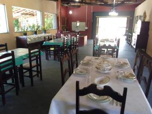 a dining room with tables and chairs with plates on them at Pousada e Pesqueiro Trem do Peixe in Monte Alegre do Sul