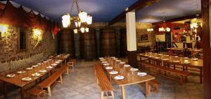 um grande quarto com mesas e cadeiras de madeira num restaurante em Agroturismo Sidreria Txindurri Iturri em Deba