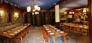 Habitación grande con mesas de madera y sillas en un restaurante en Agroturismo Sidreria Txindurri Iturri, en Deba