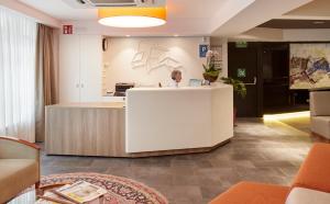 a woman standing at a reception desk in a lobby at Hotel Parma in San Sebastián