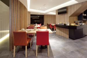 a restaurant with a table and chairs and a kitchen at Hotel Parma in San Sebastián