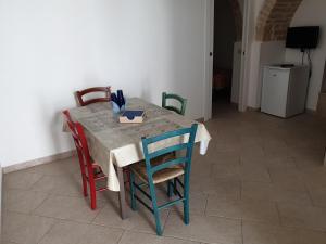 a dining room table with four chairs and a tableablish at Nonna Livia by La Puglia in un trullo in Alberobello +3 photos