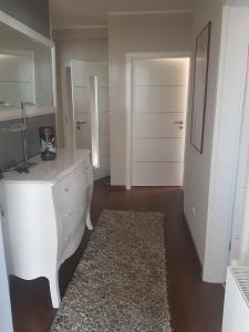 baño con cómoda blanca y alfombra en Apartman Stegić, en Šibenik
