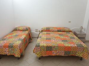 two beds sitting next to each other in a bedroom at Nonna Livia by La Puglia in un trullo in Alberobello