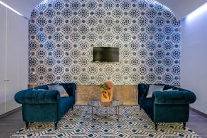 a living room with two blue couches and a tv at Tandem Palacio Alfama Suites in Lisbon