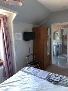 a bedroom with a bed and a tv on the wall at Drumdale Bed and Breakfast in Inverness