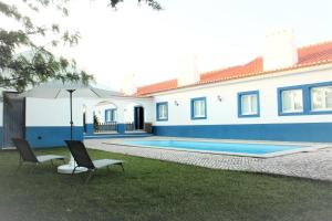 een huis met 2 stoelen en een zwembad bij Azul Coruche in Coruche