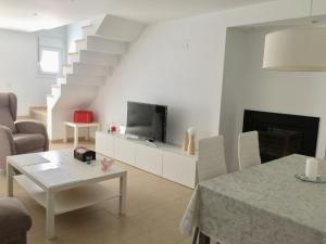 salon z telewizorem, kanapą i stołem w obiekcie Casa Luz w mieście Tarifa
