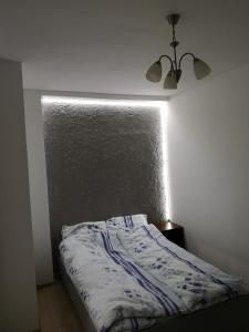 a bed in a white room with a wall at Lubawskie Zacisze in Lubawka