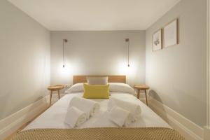 1 Schlafzimmer mit einem großen weißen Bett und 2 Nachttischen in der Unterkunft Tripas-Coração, Santa Teresa in Porto