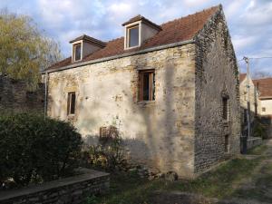an old stone building with two windows on it at La Grange in Saint-Père